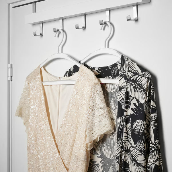 Two dresses hanging securely on IKEA TRYSSE white anti-slip hanger showing fabric grip in use