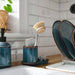 IKEA TVÅLSJÖN blue bathroom set styled on a sink, tray holding toothbrush and scouring pad
