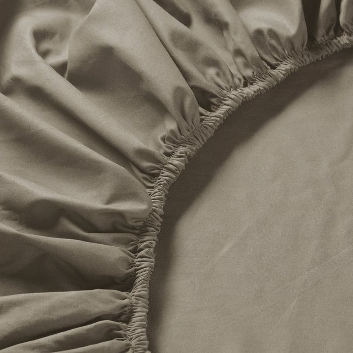 Close-up of IKEA ULLVIDE grey-beige fitted sheet showing tight percale weave and elastic edge detail