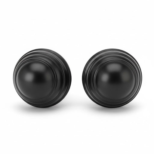 Pair of IKEA FASTSTALLA finials in glossy black with concentric ridges, designed to cap curtain rods with a sleek finish
