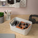 IKEA UPPDATERA white box on wooden desk storing office supplies headphones and stationery