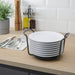 IKEA UPPDATERA plate holder anthracite stacking white plates on a wooden kitchen countertop with utensils