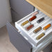 Open kitchen drawer with IKEA UPPDATERA spice rack holding neatly arranged spice jars beside wooden utensils