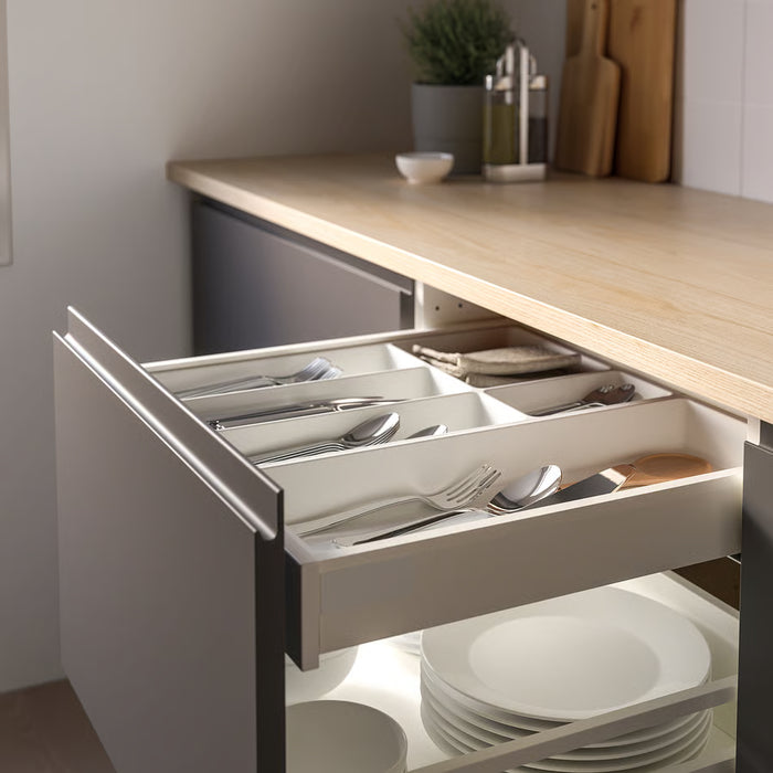  Open kitchen drawer with IKEA UPPDATERA white utensil tray organising cutlery alongside stacked plates below