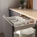  Open kitchen drawer with IKEA UPPDATERA white utensil tray organising cutlery alongside stacked plates below