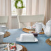 IKEA UPPLAGA butter dish on dining table set with teapot cups and blue tablecloth