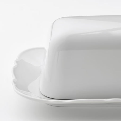 IKEA UPPLAGA white porcelain butter dish with ruffled edge on white surface close view