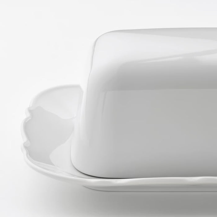 IKEA UPPLAGA white porcelain butter dish with ruffled edge on white surface close view
