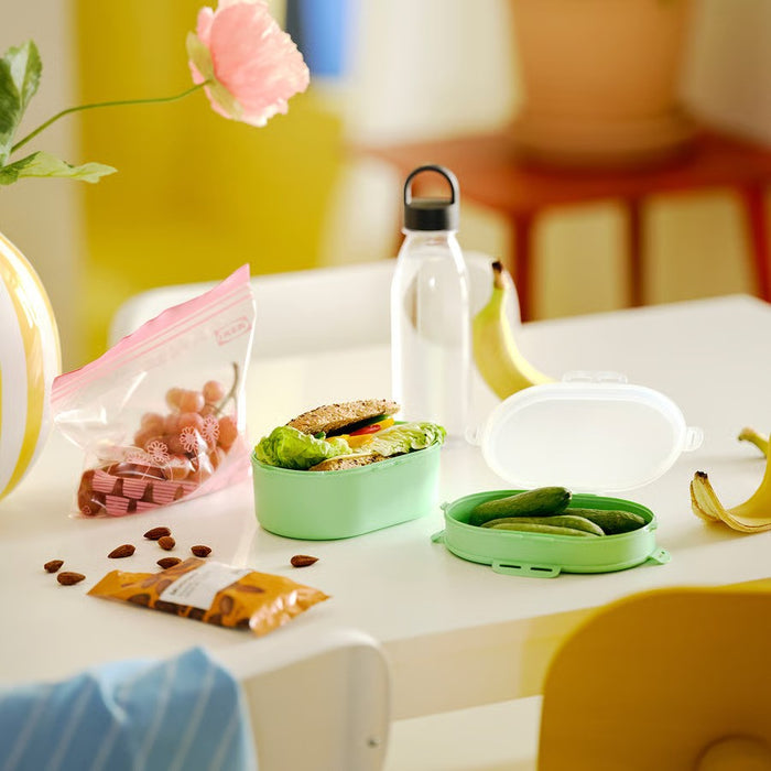 Light green UTBJUDA lunch box placed on a kitchen counter, ready for packing snacks or pasta.

