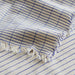Close-up of IKEA VÄLVÅRDAD tea towel white blue stripes fringe texture cotton linen weave detail