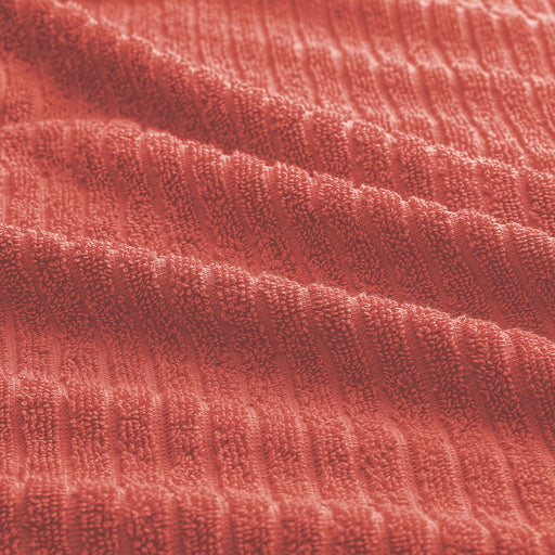 Close-up of IKEA VÅGSJÖN orange-red bath towel showing soft ribbed weave and plush terry texture