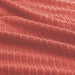 Close-up of IKEA VÅGSJÖN orange-red bath towel showing soft ribbed weave and plush terry texture