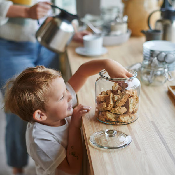IKEA VARDAGEN clear glass cookie jar on wooden table with child reaching for cookies