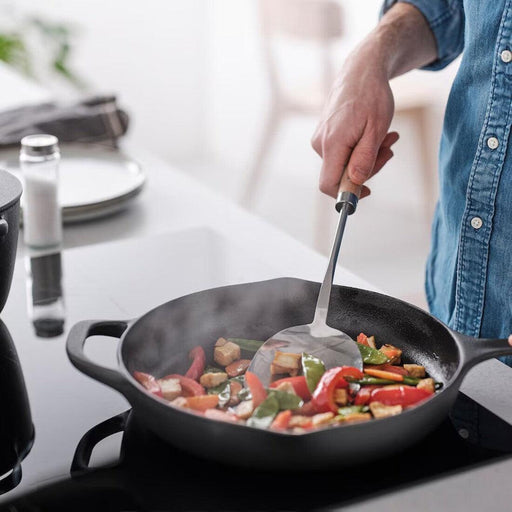  IKEA VARDAGEN wok spatula being used to stir-fry colourful vegetables in a black wok on a modern stove