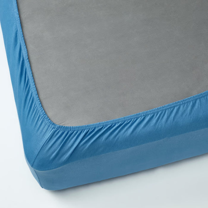 Neatly made bed with IKEA VÅRVIAL blue fitted sheet and white pillows, smooth fit