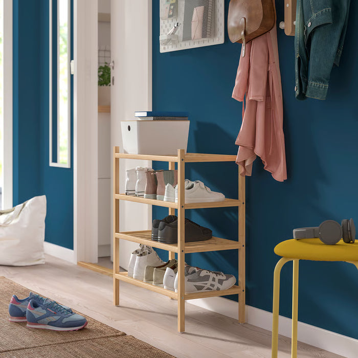 IKEA VASSKÄR bamboo shoe rack styled in an entryway with dark blue wall hanging coats and yellow stool