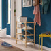 IKEA VASSKÄR bamboo shoe rack styled in an entryway with dark blue wall hanging coats and yellow stool