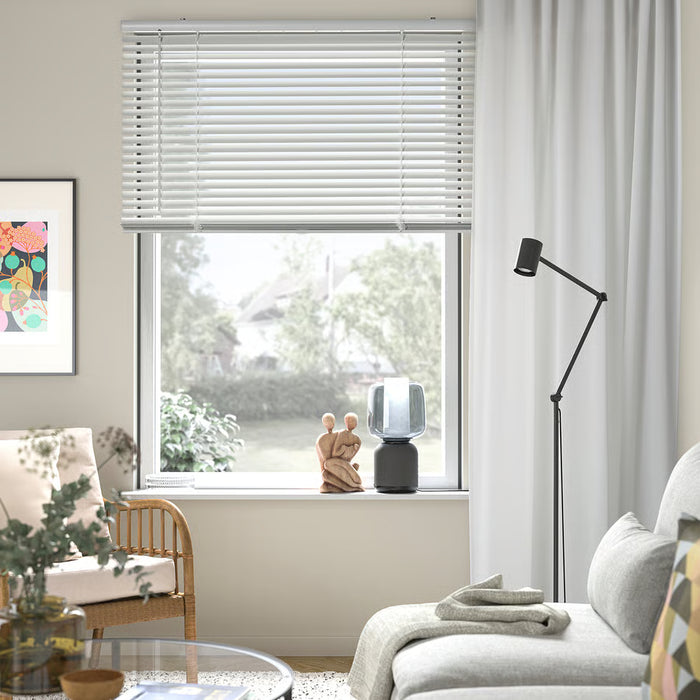 Bedroom window with IKEA VECKLARFLY white venetian blinds paired with light grey curtains and plants
