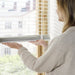 IKEA VECKLARFLY white venetian blinds with aluminium slats in living room with chair and lamp