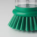 Close-up of IKEA VIDEVECKMAL green dish brush showing transparent handle, pressure dispenser system, and dense bristles