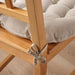 Close-up of IKEA VIPPÄRT beige chair pad showing fabric ties attached to wooden chair leg