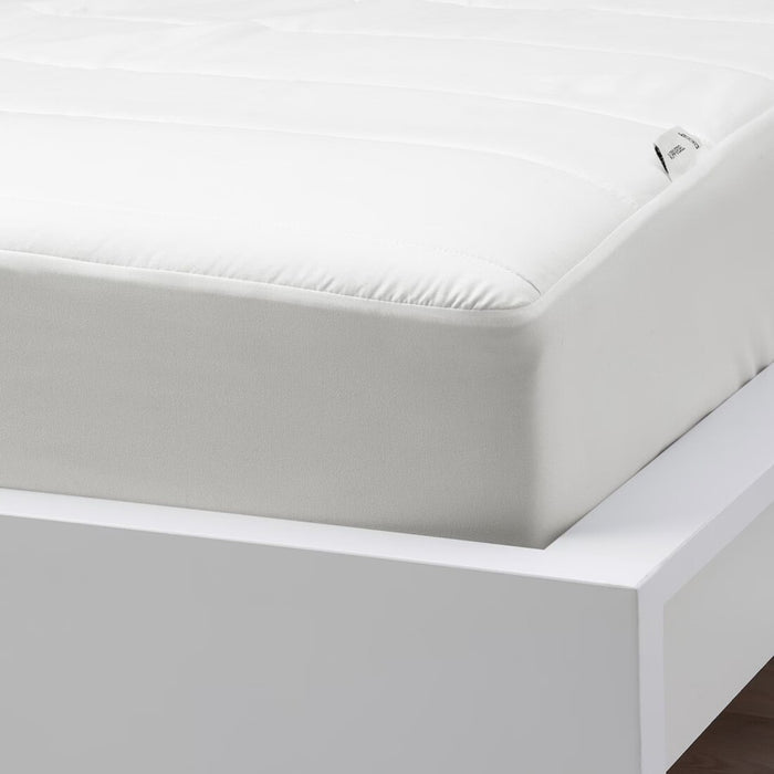 White mattress with a fitted IKEA VIPPVEDEL mattress protector, featuring stitched detailing and a small corner tag. Designed for comfort and protection against stains and dust."