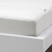 White mattress with a fitted IKEA VIPPVEDEL mattress protector, featuring stitched detailing and a small corner tag. Designed for comfort and protection against stains and dust."
