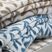 Stacked IKEA VITBACKEN cotton terry towels in blue and white leaf patterns