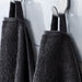 IKEA VITBACKEN grey bath towels hanging on hooks using their loops for easy hanging