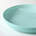 IKEA VITBLECKA turquoise plate 25cm side angle showing depth and smooth opal glass finish