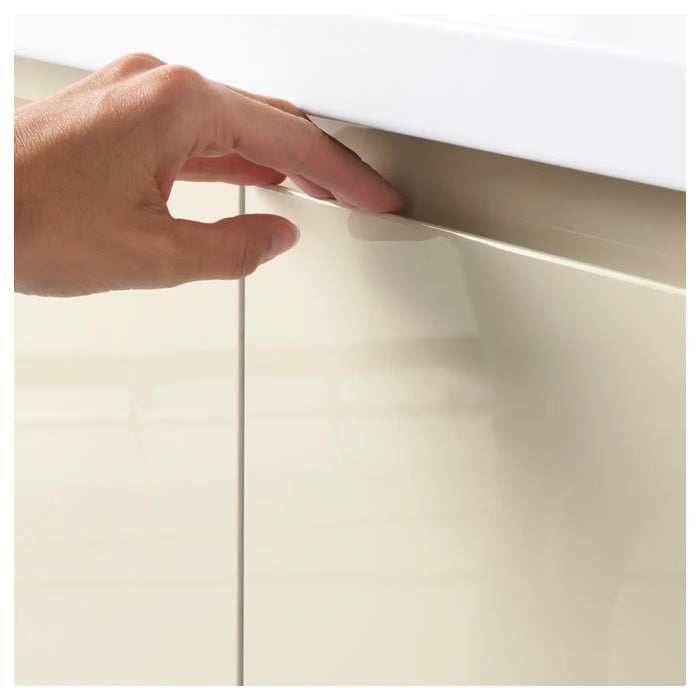 Close-up of IKEA VOXTORP light beige high-gloss door surface showing integrated handle detail