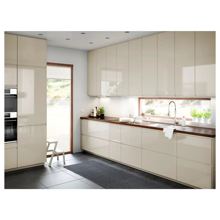 Modern kitchen with beige cabinets, wooden countertops, and a sink.