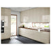 Modern kitchen with beige cabinets, wooden countertops, and a sink.