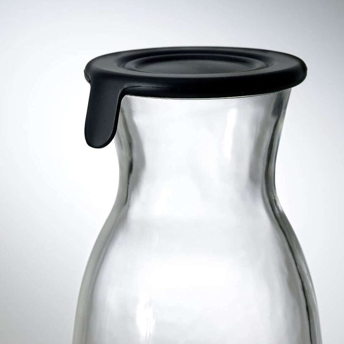 Digital Shoppy Ikea carafe with lid , A side view image of an IKEA carafe with a clear glass body and a lid made of cork. The carafe is filled with iced tea and placed on a black granite countertop in a modern kitchen. 302.919.22