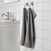 An image of a Grey hand towel hanging from a hook on a bathroom wall 90512874