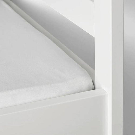 A closeup image of IKEA fitted sheet on a bed with neatly tucked corners and a smooth surface  80203490