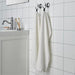 An image of a White hand towel hanging from a hook on a bathroom wall 30512886