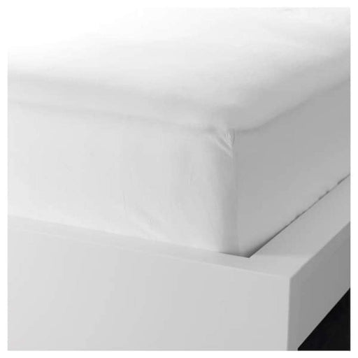 A closeup image of IKEA fitted sheet on a bed with neatly tucked corners and a smooth surface -40360533