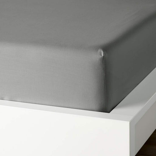 A closeup image of IKEA fitted sheet on a bed with neatly tucked corners and a smooth surface