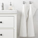A classic white hand towel with a simple and elegant border design, perfect for any bathroom