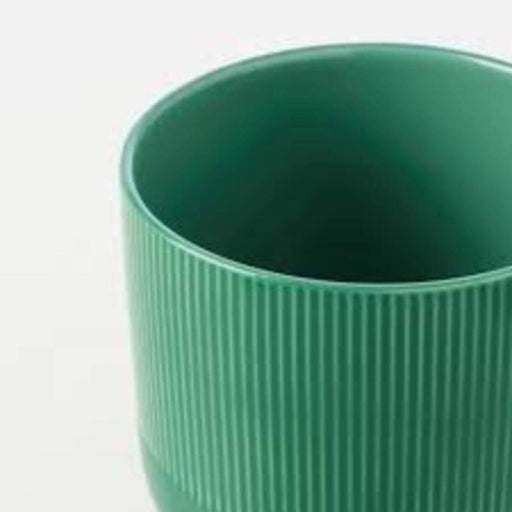 A round plant pot with a textured surface and a narrow opening, holding a small green plant.60452715