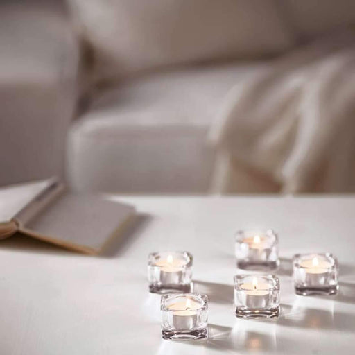 A clear glass jar containing a beautiful unscented candle, perfect for enhancing the ambiance of any room.
