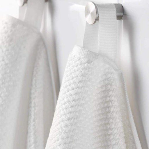 A close-up image of a folded white hand towel with a textured pattern 80313224