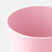 A small, round plant pot in a matte pink color.