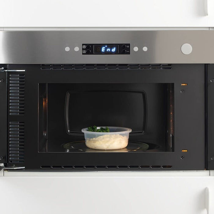 An image of a person using a microwave to heat up a food container with a vented lid from IKEA  50359143,10393498