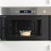 An image of a person using a microwave to heat up a food container with a vented lid from IKEA  50359143,10393498