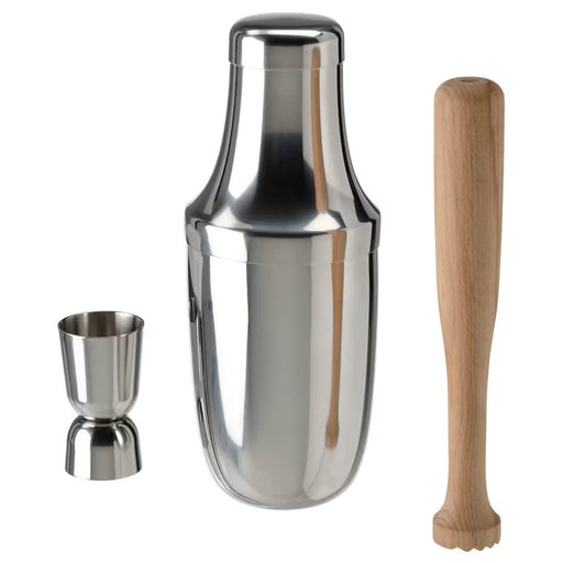 A close-up of a stainless steel cocktail shaker with a built-in strainer and a jigger.