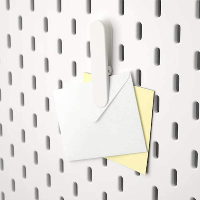 A close-up of an IKEA pegboard clip, emphasizing its simple and functional design. 70321615