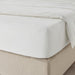 A closeup image of IKEA fitted sheet on a bed with neatly tucked corners and a smooth surface  10357160