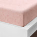 A closeup image of IKEA fitted sheet on a bed with neatly tucked corners and a smooth surface  60501612